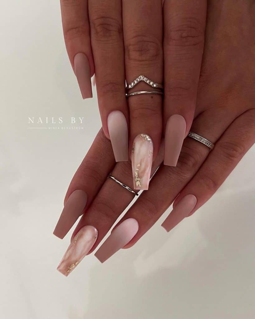 Standout white nails boast a chic marble design crowned with gold foil for that extra sparkle.