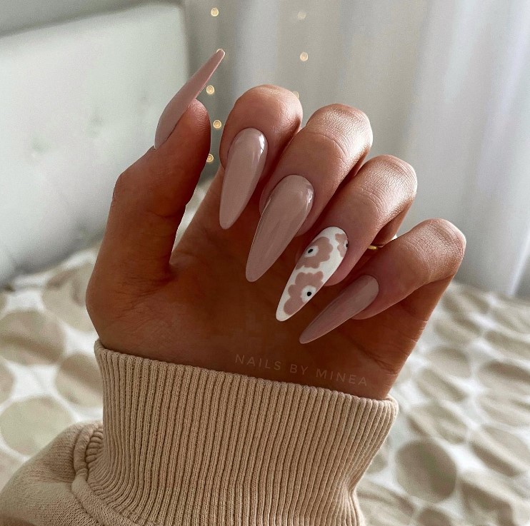 Try these glossy mocha nails that contrast nicely with an accent nail in white featuring cartoon flowers with petals that echo the deep brown shade.
