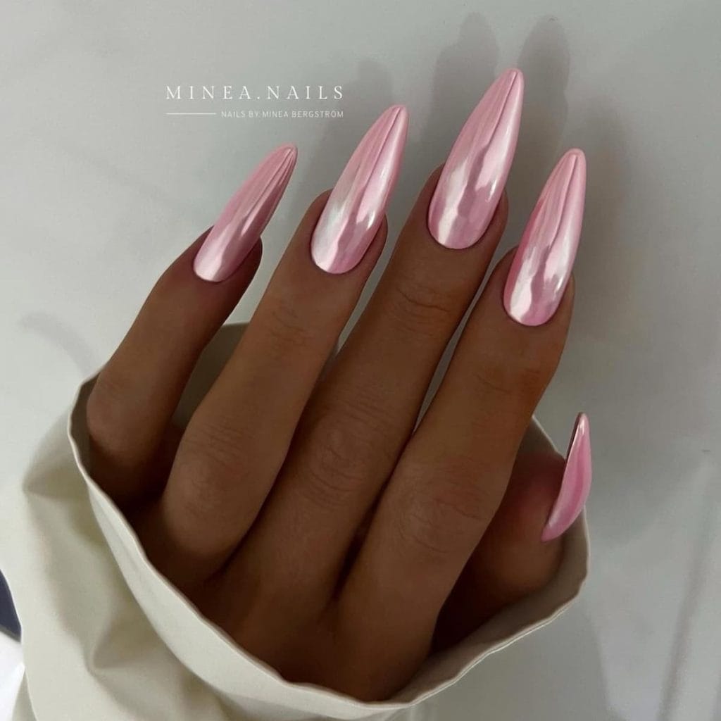 A woman holding a plain soft pink chrome nails.
