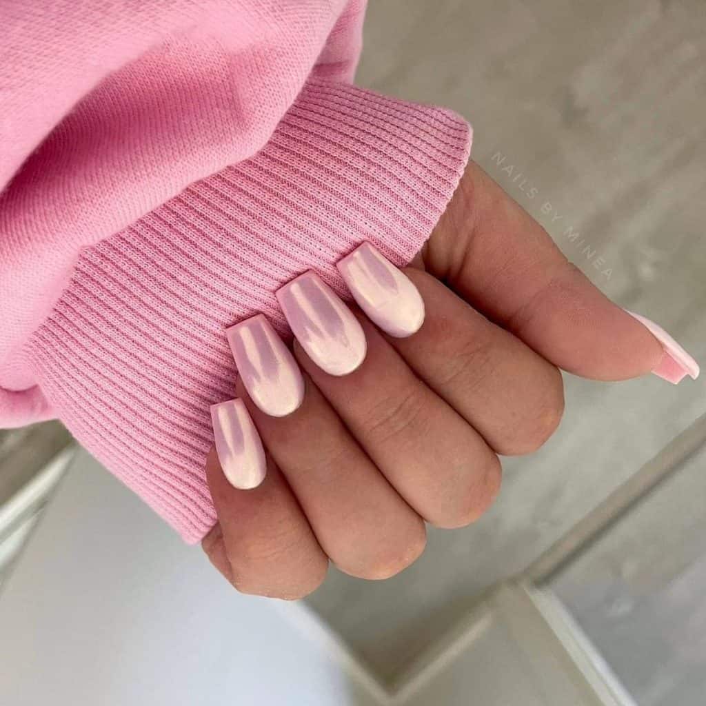 A woman with light pink chrome nails in a squoval shape