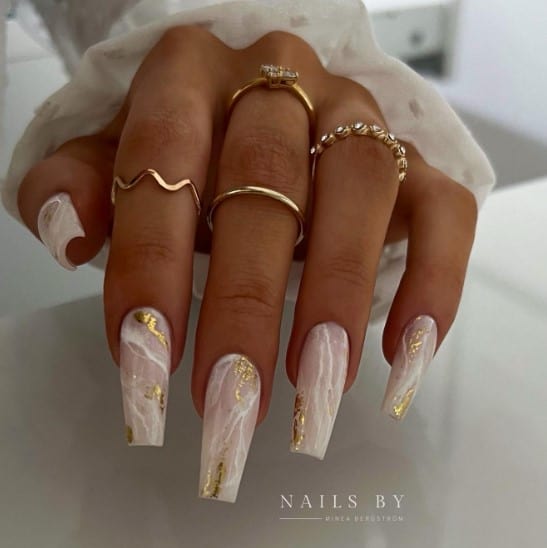 The pinkish-white base decorated with abstract streaks and gold smears is a unique twist on the classic look.