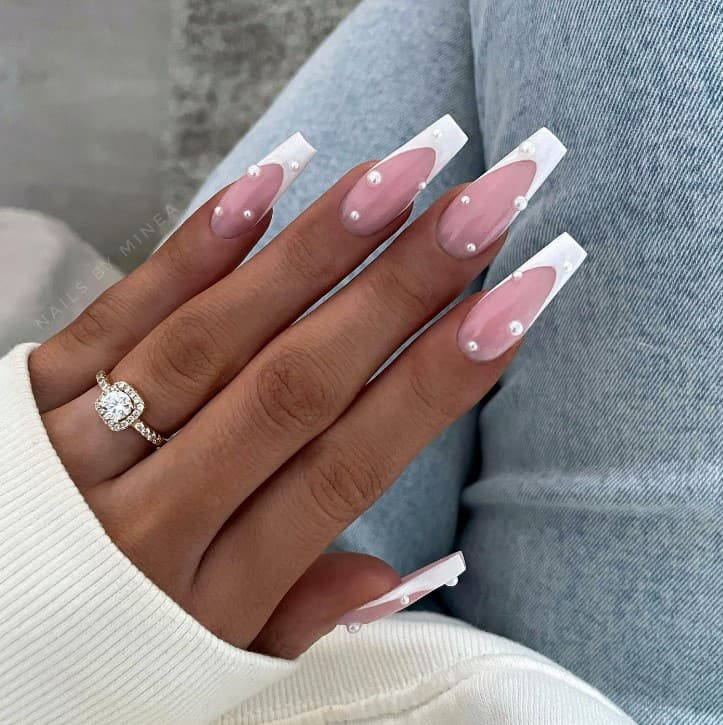 These long white French tip coffin nails are accentuated with pearl studs, making the classic nail design stand out even more.