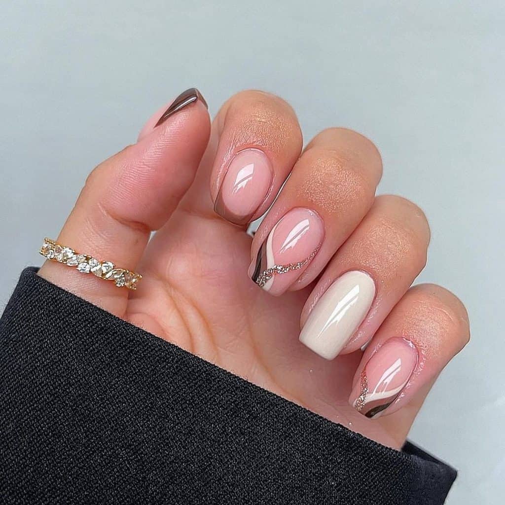 A woman's hand holding a brown aesthetic nails design.