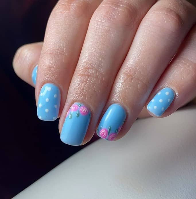 All short squoval nails feature a baby blue base, with three sporting playful white polka dots. 