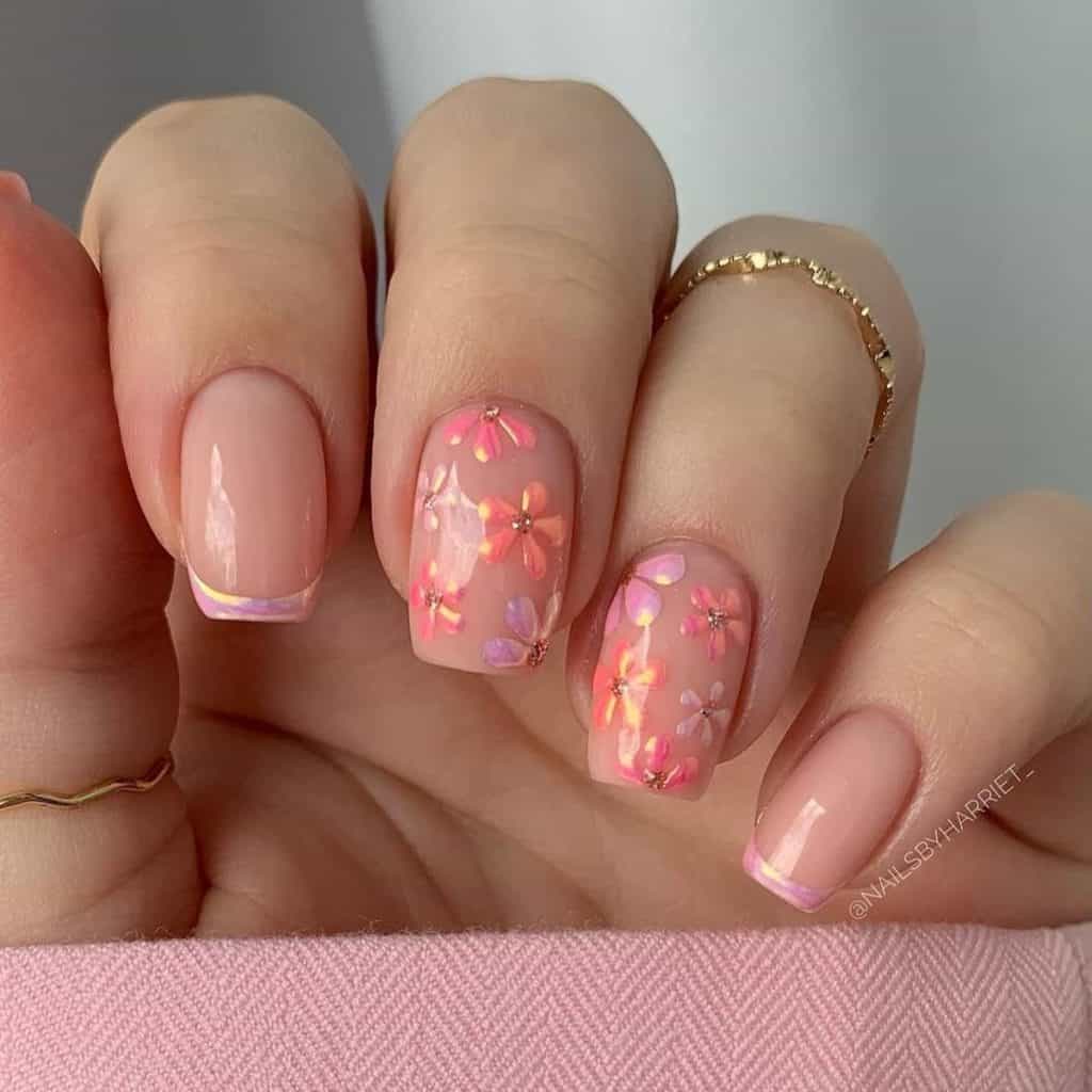 A woman's nude base nails decorated with chrome pink French tips and accented with vibrant flowers in chrome shades of coral, lavender, and pink, each with a glittery rose gold center