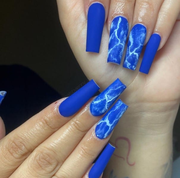 A woman with coffin-shaped blue and white marble nails.