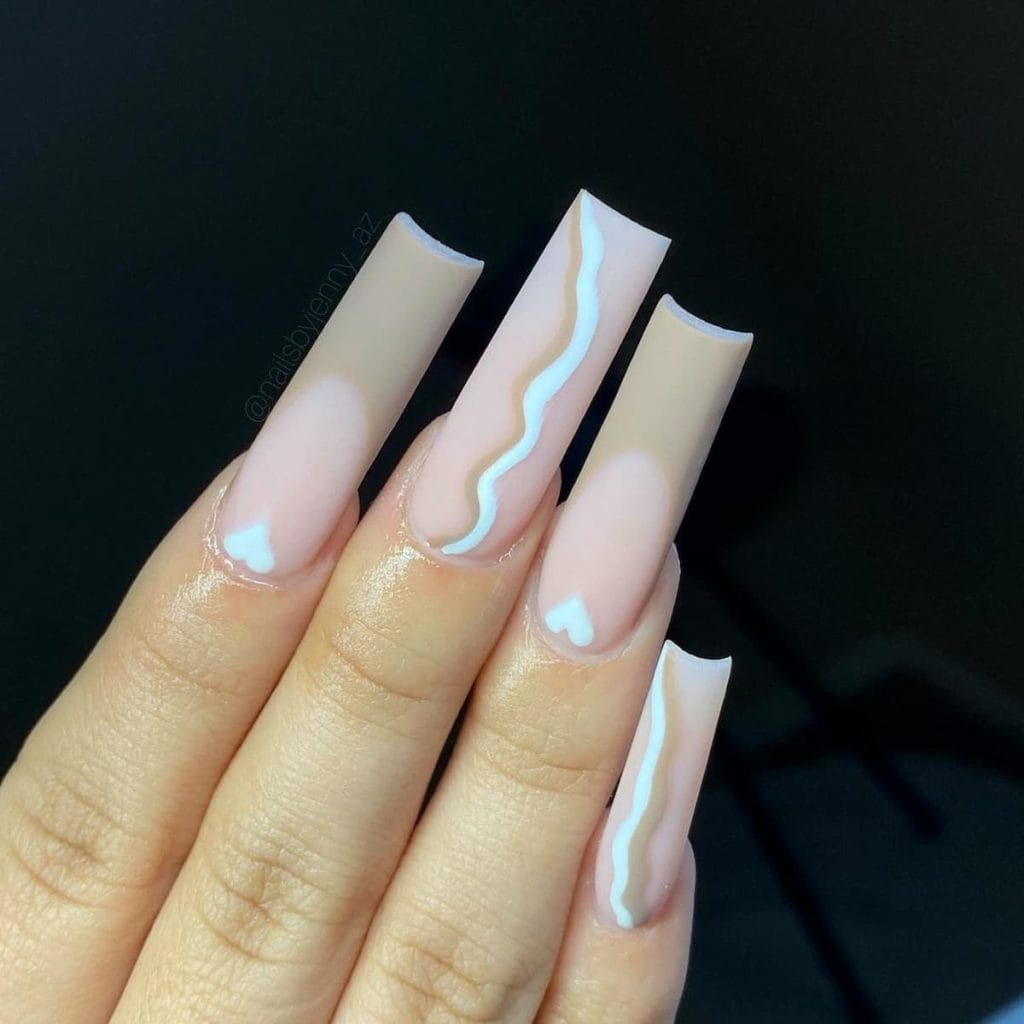 Nude pink matte nails alternate between two charming designs: subtle nude brown French tips with a tiny heart and elegant vertical swirl lines in a white and nude brown duet
