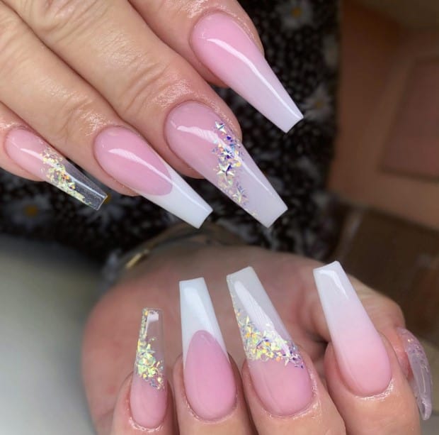 A woman's pink and white coffin nails with glitter.