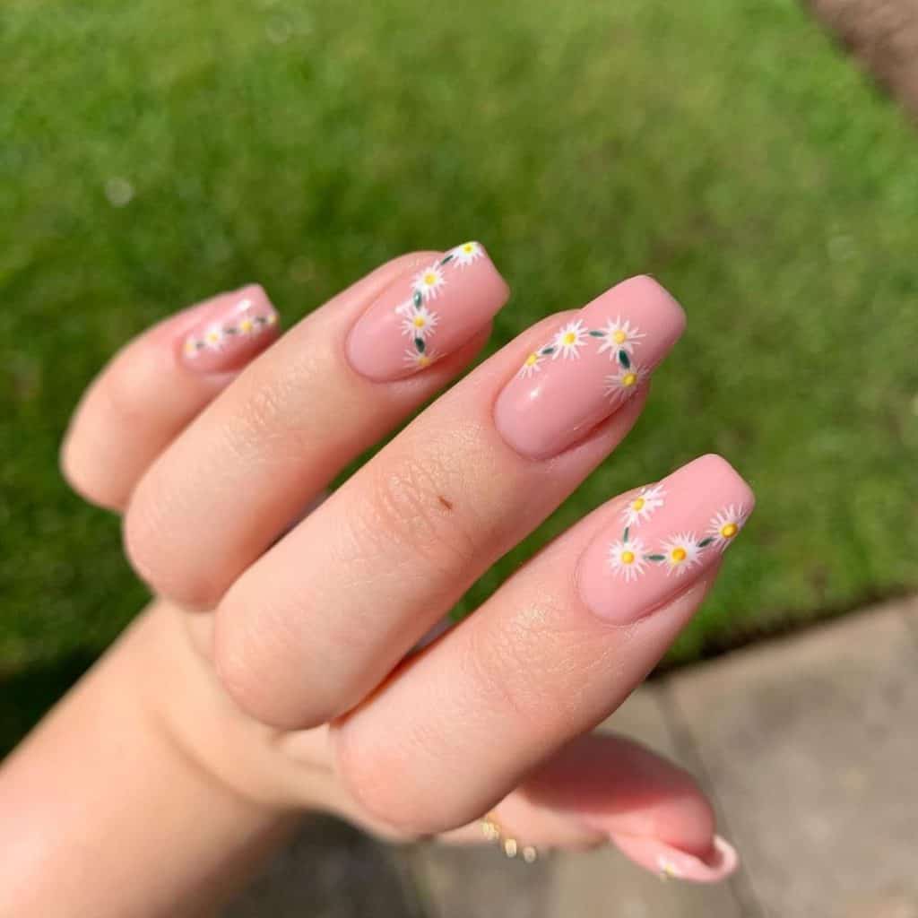 Envision dainty nails where tiny white blossoms trail across each nude light pink nail, connected by a painted green rope.