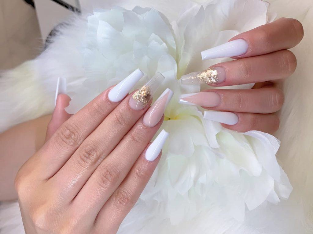 A woman with coffin nails and a flower in hand.