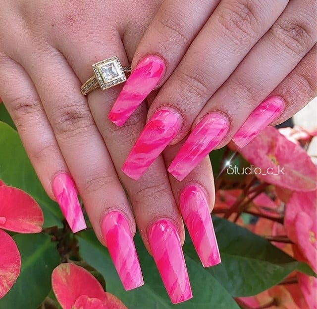 A woman with coffin nails holding a ring.