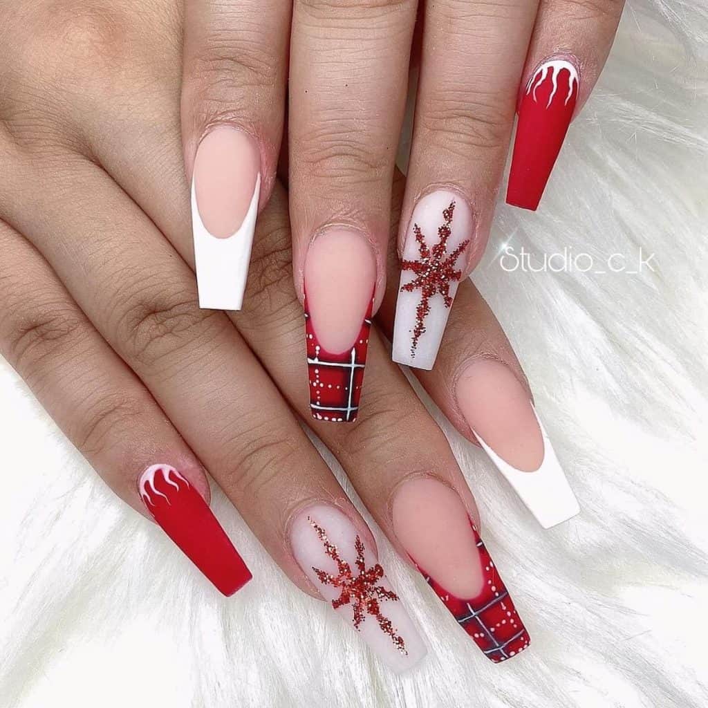dark matte red nails are adorned with white icicle art at the cuticles. 