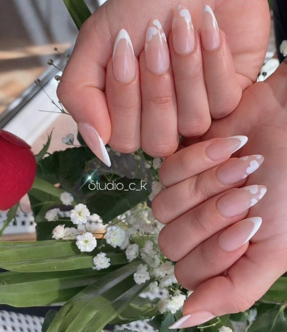 Nude almond nails are the epitome of love, featuring pristine white French tips. 