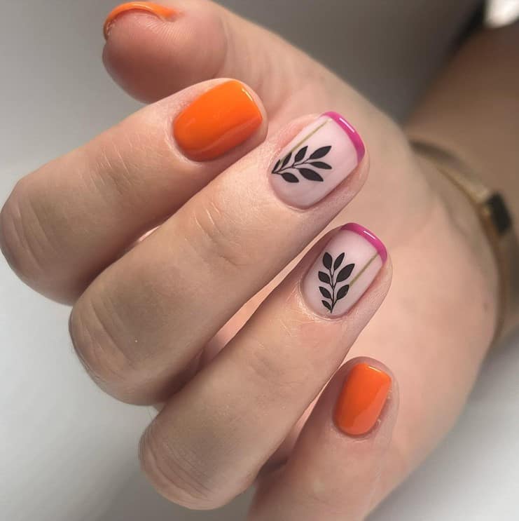 Bright orange short squoval nails make a statement, while accent nails in nude pink are detailed with magenta tips. 