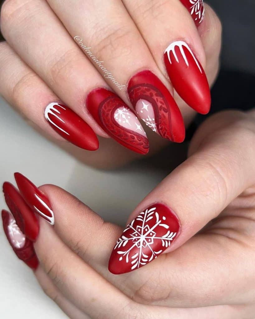 A woman's feature intricate white snowflake art, frosty spikes near the cuticles, and a heartwarming diptych of a red heart outlined in a sweater knit pattern that reveals a nude base kissed by white dots and stars.