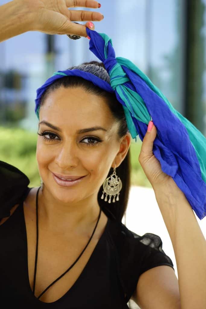 A woman wearing a blue and green head scarf.