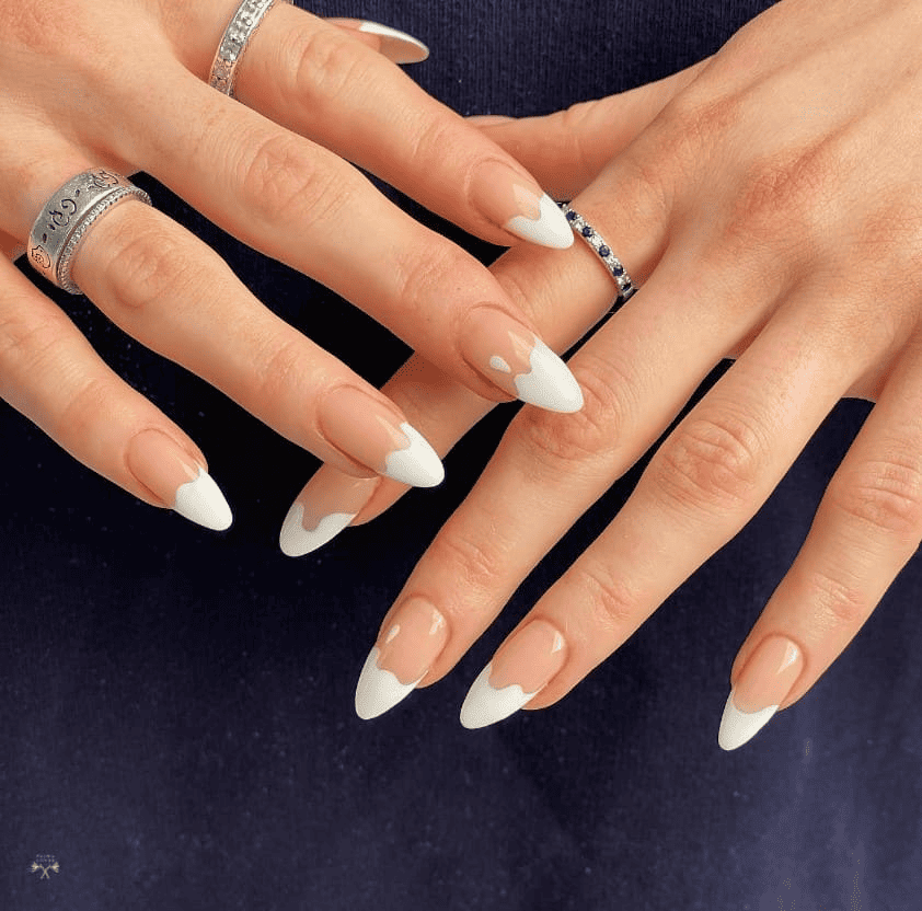 A woman's hands with white nails and rings.