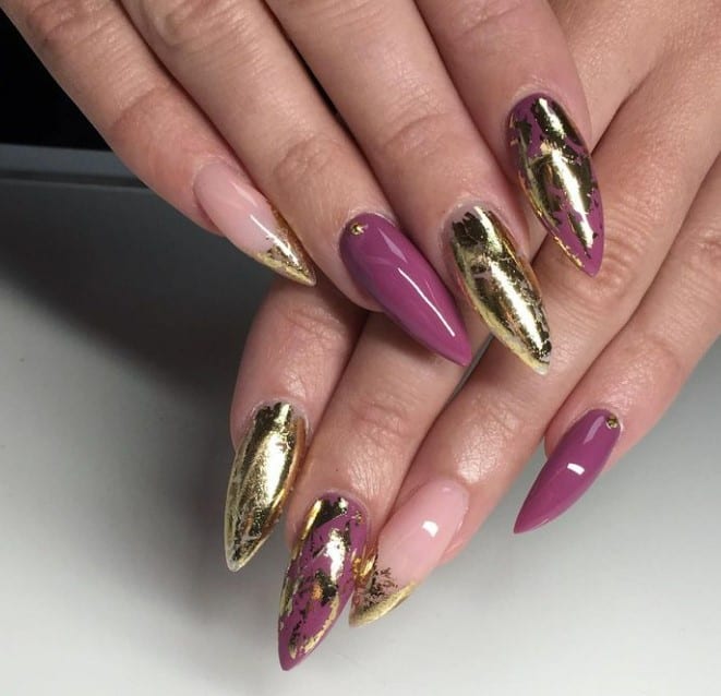 Imagine stiletto nails bathed in glossy pinkish-mauve and nude, each one with varying gold embellishments. 