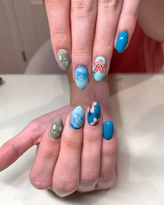 Tell your own unique cruise story with designs like clear water, florals, and footprints in the sand on light teal and deep blue nails. 