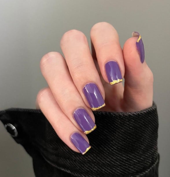 A unique and sophisticated version of French tips, these purple square nails have each tip adorned with a dash of glittery gold.