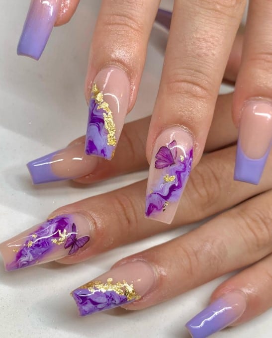These beautiful acrylic nails are a daydream, featuring lavender tips, nude-and-lavender ombré, and purple marble swirls accented with gold foil. 