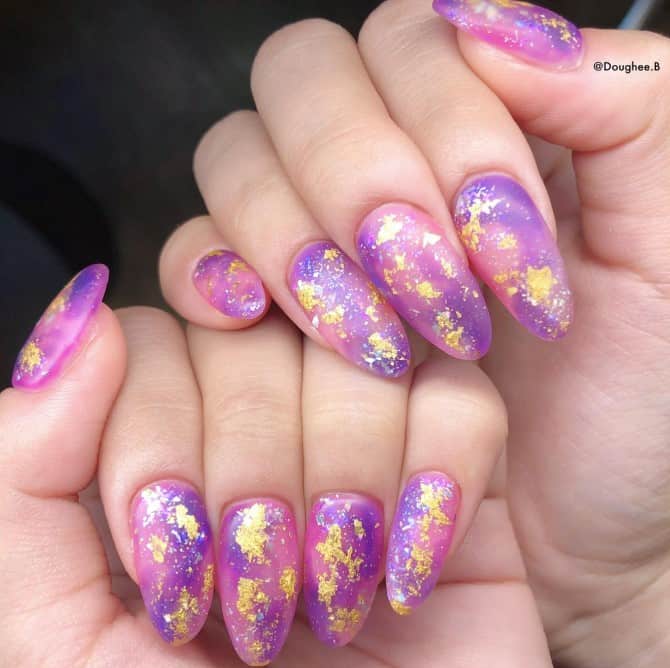 Drift through the cosmos with nails in a swirl of purples and pinks, highlighted with gold foil and a sprinkle of glitter.