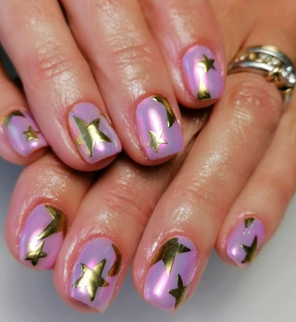 The chrome purple nails serve as the canvas for golden stars to shine and twinkle with every move.
