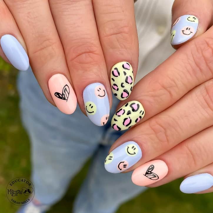 This cute leopard nail design showcases soft pastel hues that come alive with playful smiley faces and pinkleopard prints, combining quirky charm with a dash of wild in a round nail shape.