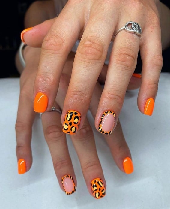 While most nails shine in full, zesty orange, two stand out: one with an all-over leopard print and the other with a leopard frame around a soft, nude center.