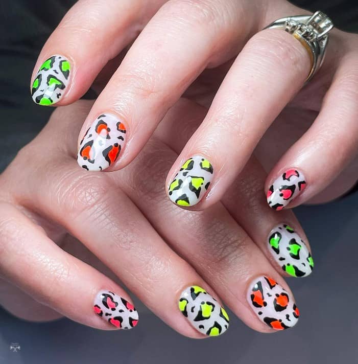 A riot of colors, these nails feature a white base with leopard spots in a different neon polish shade for each nail, such as lime green, orange, yellow, and pink, bringing a funky twist to the traditional leopard print.