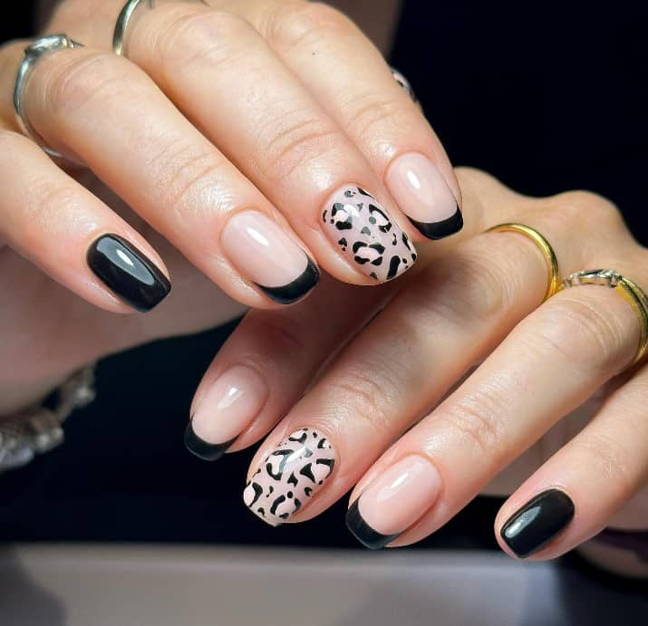 Sleek black polish graces one whole finger, a black French tip line two nude nails, and a full leopard print on the middle nail make an understated yet elegant look.
