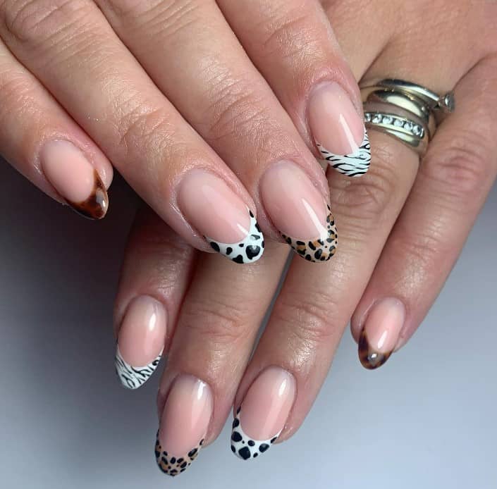 Each tip boasts a different print: leopard, tortoiseshell, cow, and zebra, blending the iconic French manicure with the wild heart of the animal kingdom.
