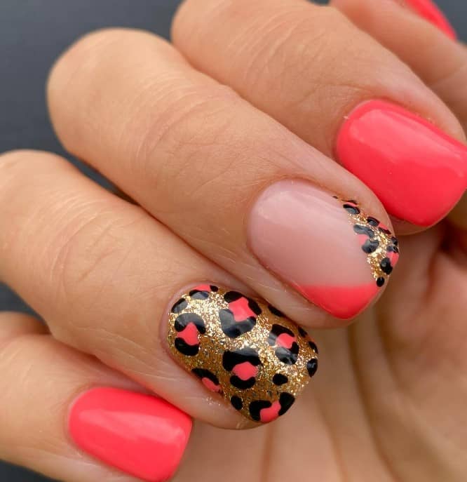 It features a V-French tip that’s half coral and half leopard, plus one adorned with coral leopard prints outlined in black against a gold glitter backdrop, offering a glamorous twist to the leopard trend.