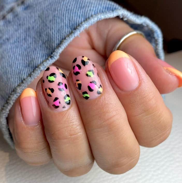 A woman's hand with pink and orange leopard print nails.